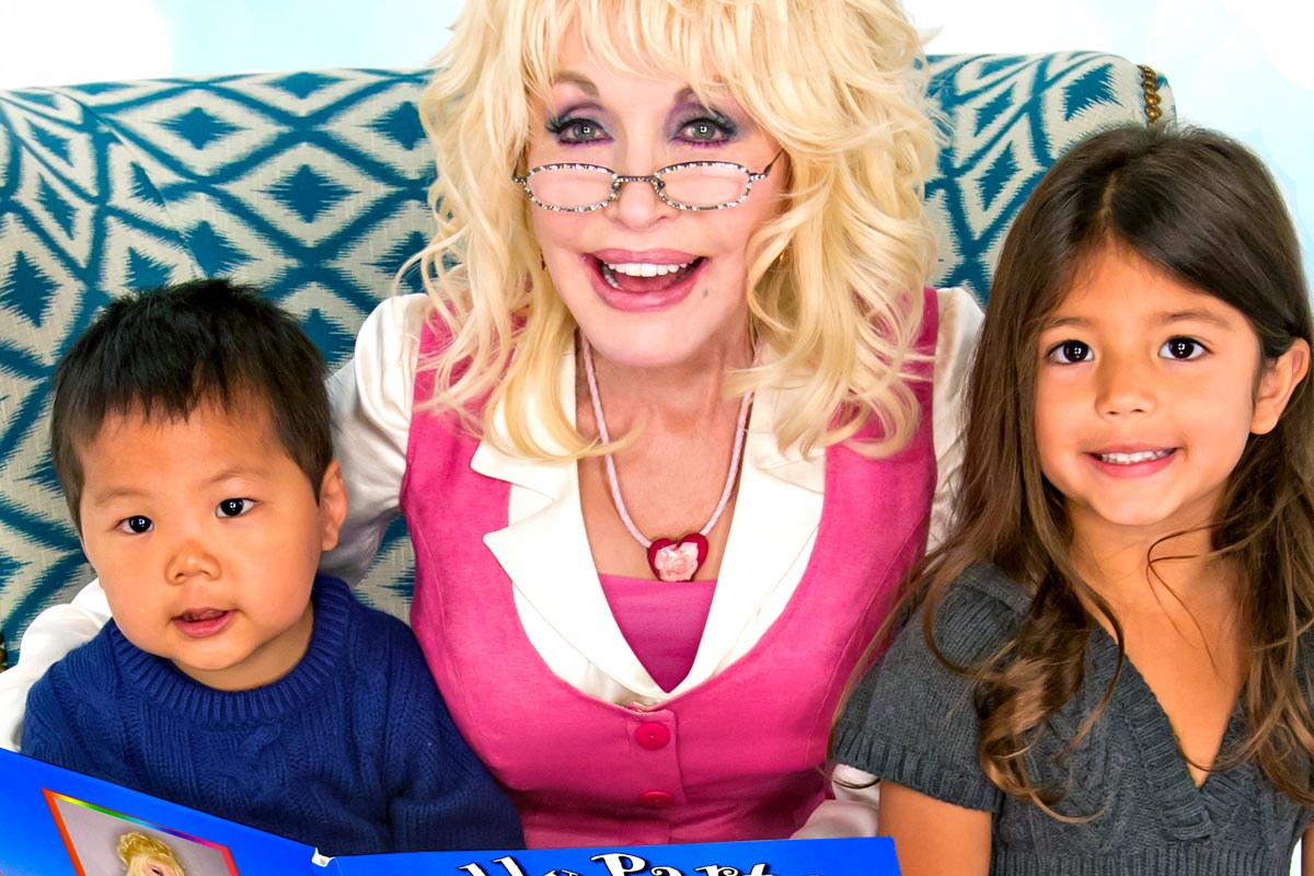 Dolly Parton reading with two children in support of Dolly Parton's Imagination Library